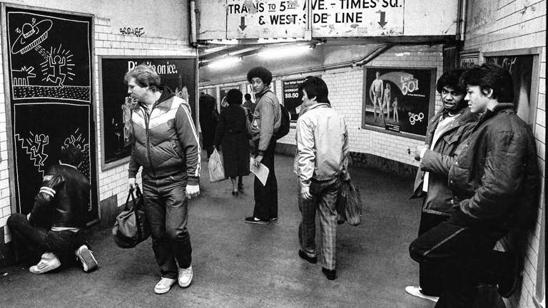 A black and white photograph of figures in the New York subway 