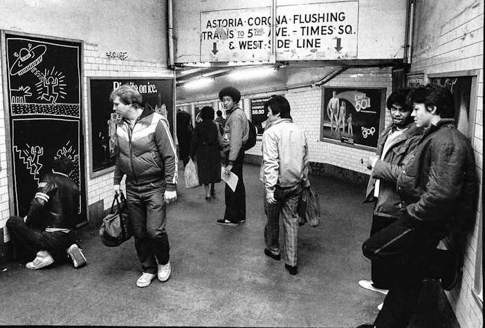 A black and white photograph of figures in the New York subway 