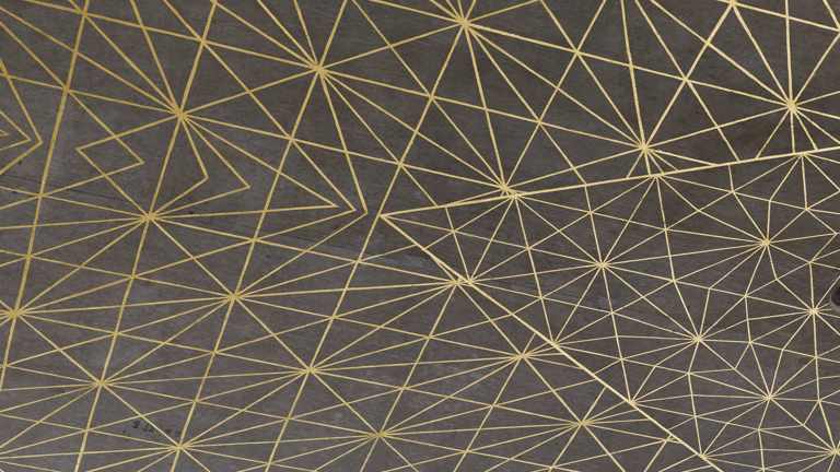 A close-up of a complex geometric pattern composed of various triangles which come together to form hexagons, rendered in gold leaf on a plain grey concrete ceiling.